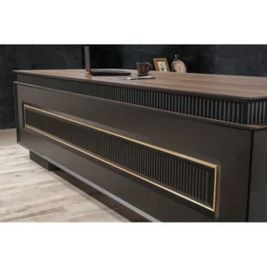 Horen makam masasının sağ yan eğimli detayı ve altın çerçeveli paneller, parlak zeminde lüks ofis ortamında yandan görünümle sergileniyor.